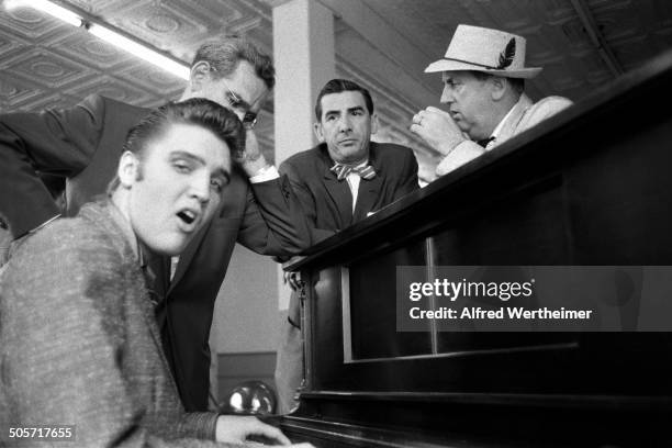 Alfred Wertheimer/MUUS Collection via Getty Images) As Colonel Tom Parker and several unidentified television executives listen, American musician...