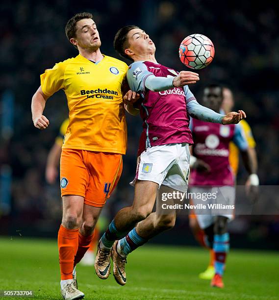 Jack Grealish of Aston Villa is challenged by Stephen McGinn of Wycombe Wanderers during the FA Cup Third Round Relay match between Aston Villa and...