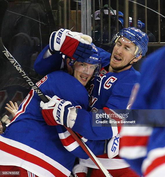 Miller of the New York Rangers celebrates his overtime game winning goal against the Vancouver Canucks along with Ryan McDonagh at Madison Square...