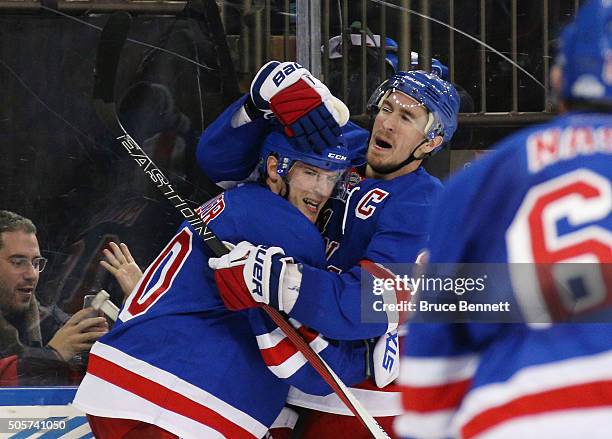 Miller of the New York Rangers celebrates his overtime game winning goal against the Vancouver Canucks along with Ryan McDonagh at Madison Square...