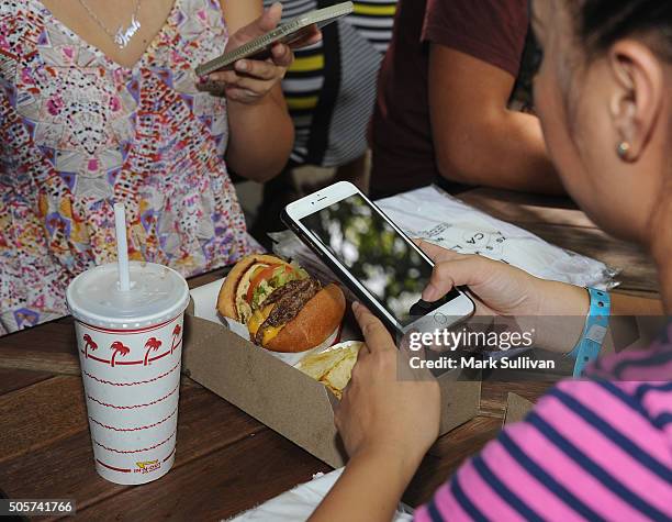 Customer photographs her burger at the In-N-Out Burger pop-up in Surry Hills on January 20, 2016 in Sydney, Australia. It's the second time the...