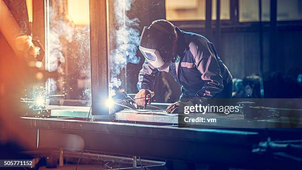 industrial worker with welding tool - ijzer stockfoto's en -beelden