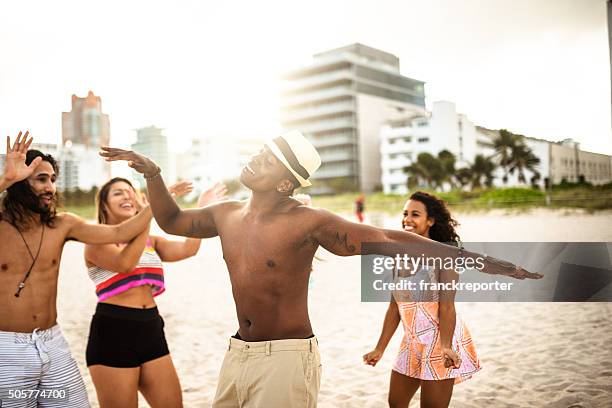 friends dancing on the beach for a party - miami party stock pictures, royalty-free photos & images
