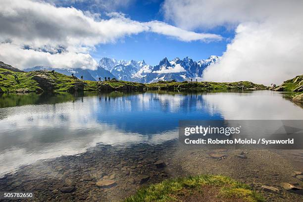 hikers at lac de cheserys france - lake chesery stockfoto's en -beelden