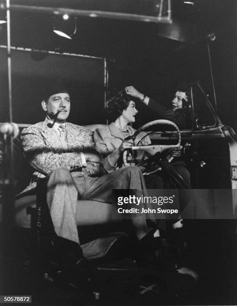 Melvyn Douglas and Myrna Loy being filmed in studio, with projected background, for Mr. Blandings Builds His Dream House.