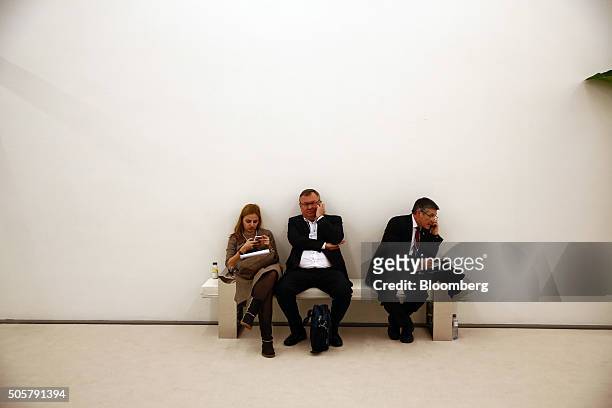 Andrey Kostin, chief executive officer of VTB Bank PJSC, centre, sits on a bench and makes a telephone call between sessions during the World...