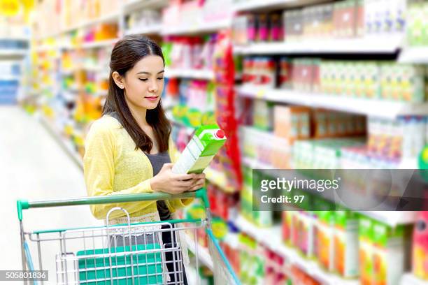 asian woman in the supermarket to buy of juice - buy single word stock pictures, royalty-free photos & images