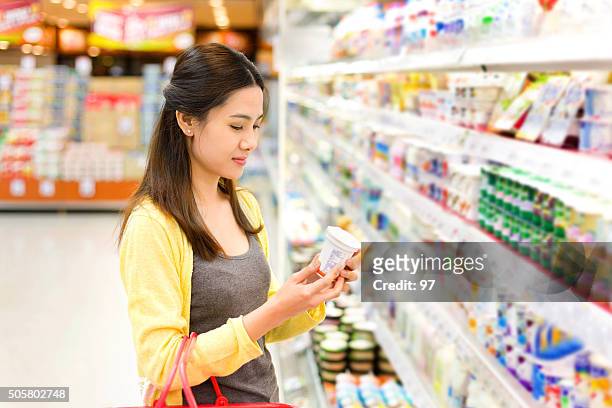 asiatische frau kauft im supermarkt joghurt - dairy product stock-fotos und bilder