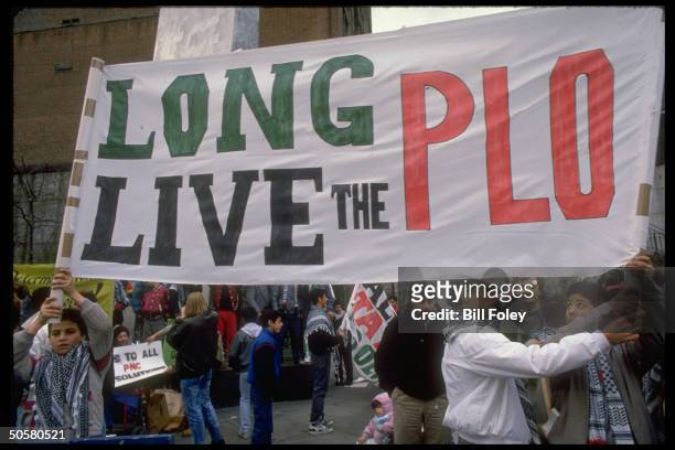 Palestinians carrying Long Live the PLO sign during demo outside UN protesting US decision not to grant PLO ldr. Yasser Arafat a visa to address UN.