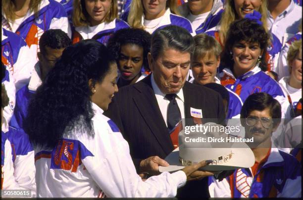 Pres. Ronald Reagan admiring cowboy hat given him by track star Florence Griffith Joyner w. Other members of US Olympic team.;1988