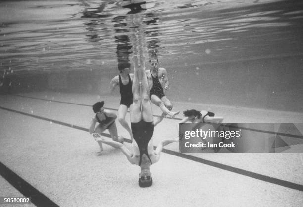 Underwater view of five male & female aquatic dancers of the French dance troupe, Astrakan performing maneuvers during aquatic dance, Waterproof in...