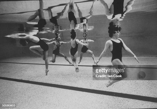 Underwater view of five male & female aquatic dancers of the French dance troupe, Astrakan performing maneuvers during aquatic dance, Waterproof in...