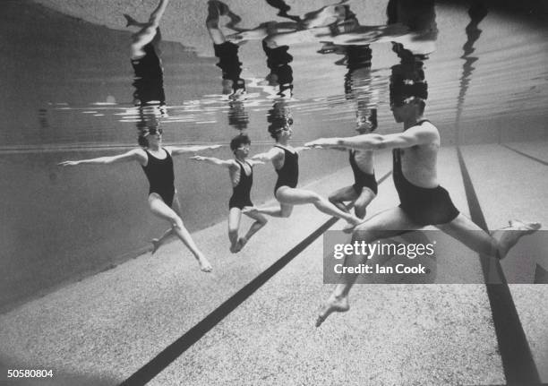 Underwater view of five male & female aquatic dancers of the French dance troupe, Astrakan performing maneuvers during aquatic dance, Waterproof in...