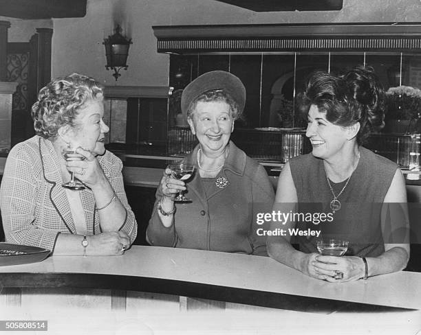 Actresses Violet Carson, Margot Bryant and Pat Phoenix, stars of the ITV soap opera 'Coronation Street', pictured having a drink at the bar during...