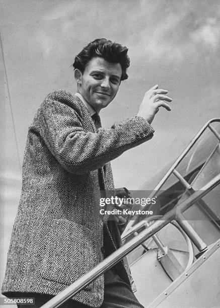 French actor Gerard Philipe waving as he boards a plane bound fro Rome, where he will begin filming 'Beauty and the Devil', July 14th 1949.