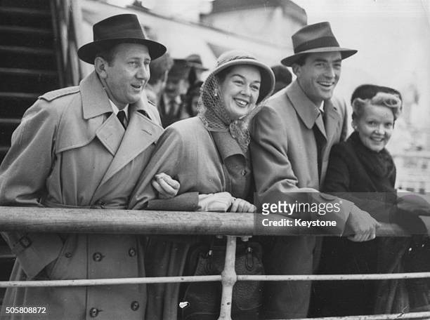 Actress Rosalind Russell and her husband, producer Frederick Brisson with actor Gregory Peck and his wife on the deck of the 'Queen Elizabeth' ship...