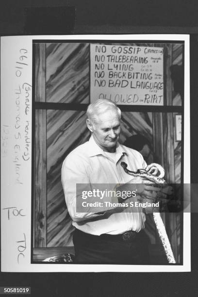 Church leader Dewey Chafin handling two timber rattlesnakes during worship service at the Church of the Lord Jesus.