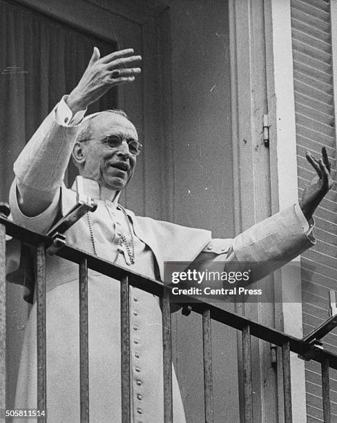 Pope Pius XII raising his hands to bless the crowd, from his balcony at Castel Gandolfo near Rome, October 9th 1958.