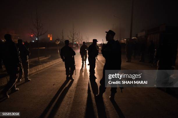 Afghan policemen keep watch at the site of suicide attack against a minibus carrying employees of popular Afghan TV channel TOLO which killed seven...