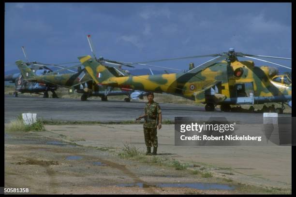 Sri Lankan Army soldier standing on airstrip w. Planes in bkgrd., .