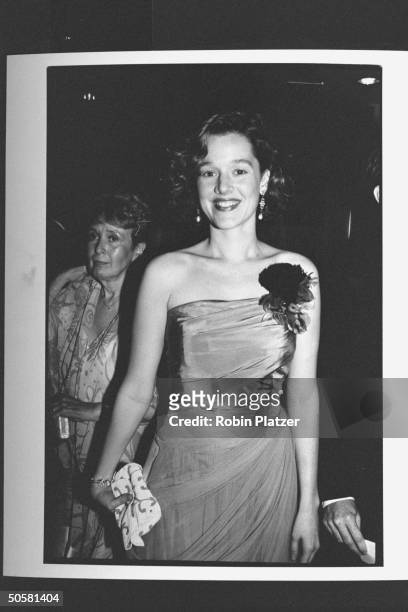 Actress Penelope Ann Miller standing holding a small beaded clutch purse at the 43rd Annual Tony Awards.
