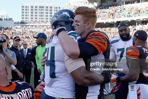 Andy Dalton of the Cincinnati Bengals shares a moment at midfield with Bobby Wagner of the Seattle Seahawks after their game at Paul Brown Stadium on...