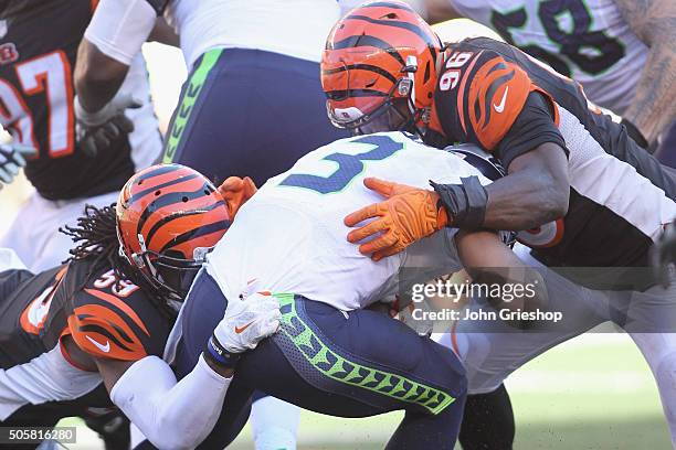 Carlos Dunlap and Emmanuel Lamur of the Cincinnati Bengals make the tackle on Russell Wilson of the Seattle Seahawks during their game at Paul Brown...