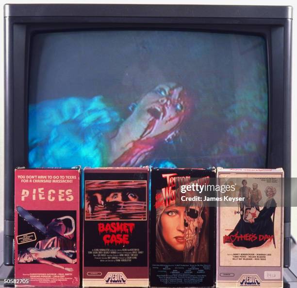 Video covers for horror films L-R: Pieces, Basket Case, Terror in the Wax Museum, and Mother's Day on top of video image of bloody terrified woman.