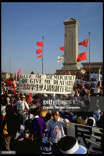 Banner in midst of crowd reading Give me democracy or give me death in English during pro-democracy protests in Tiananmen Sq.