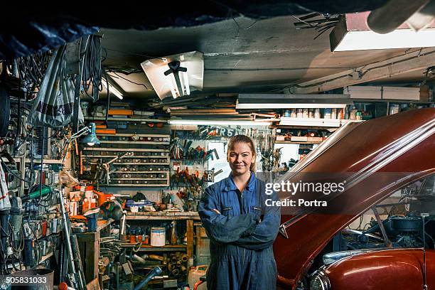 female motor mechanic standing in a garage. - workforce revolution stock-fotos und bilder