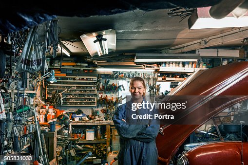 Female motor mechanic standing in a garage. Female motor mechanic standing in a garage.