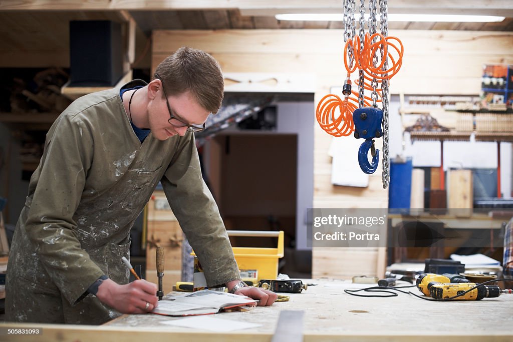 Carpenter writing in book