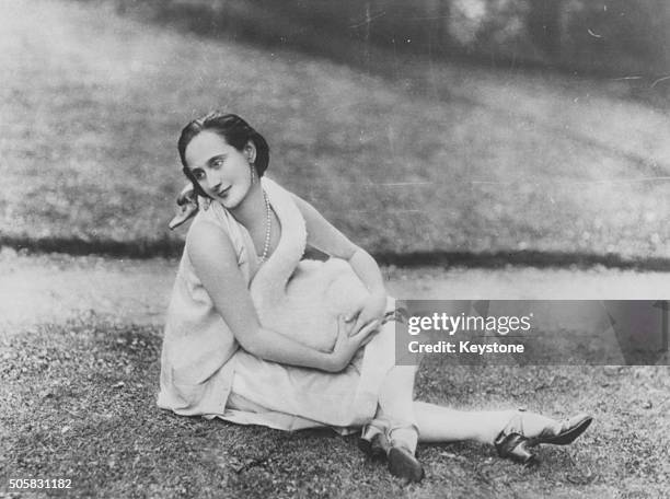 Portrait of Russian ballerina Anna Pavlova sitting on the grass outdoors, circa 1925.