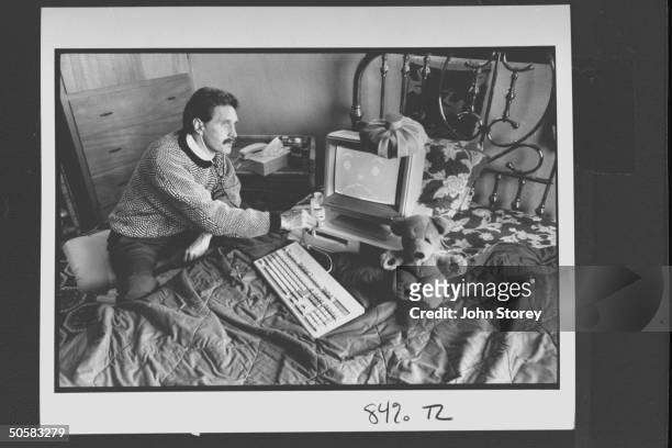 Computer analyst John McAfee holding stethoscope to IBM type computer sitting on bed w. Ice bag on top, illustrating computer virus which McAfee is...