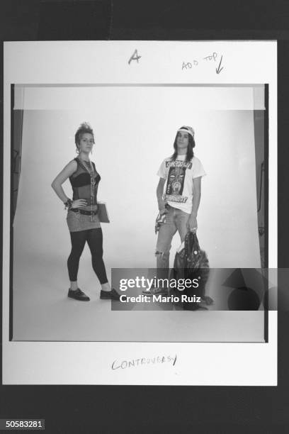 Teenage girl modeling see-through sleeveless blouse, miniskirt over black tights, clunky shoes, hoop earrings & peace symbol necklace w. Boy sporting...