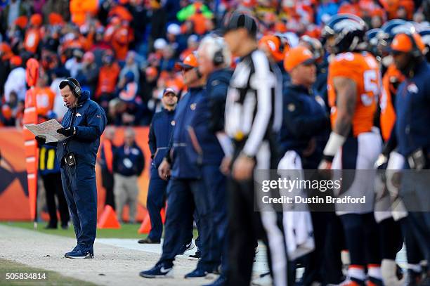 Head coach Gary Kubiak of the Denver Broncos consults his playbook on the sideline during the AFC Divisional Playoff Game against the Pittsburgh...