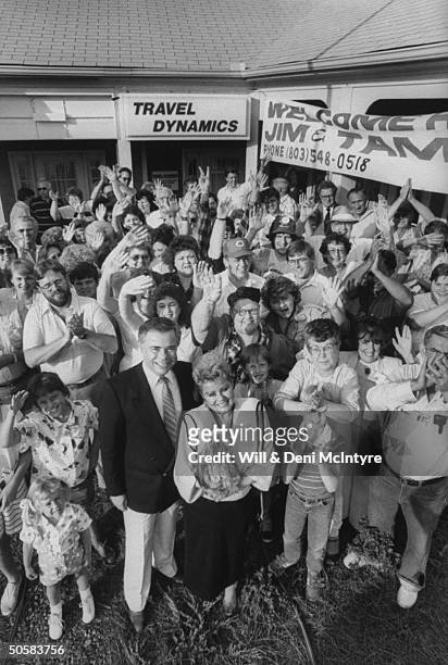 Overhead portrait of disgraced PTL evangelist Jim Bakker and his wife Tammy Faye, surrounded by members of the Bring Bakkers Back group, outside the...
