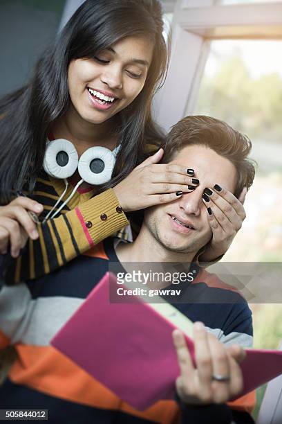 late teen girl covering eyes from behind of a boy. - girlfriend stock pictures, royalty-free photos & images
