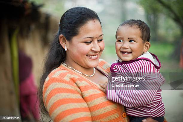 happy asian woman lifting up her child in arms. - nepal children stock pictures, royalty-free photos & images