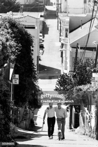 Gay writer Armistead Maupin walking w. Arm around lover Terry Anderson who tests HIV-positive & is taking AZT; seen walking their dog Willie.