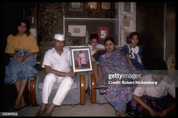 Family of Monica Chadha, student who self-immolated herself to protest proposed quotas on govt. Jobs for backward castes, holding her portrait.