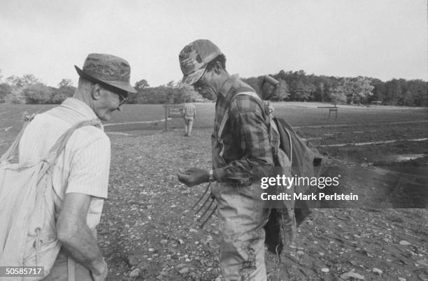 Diamond prospectors Jim Archer & friend Joe Fedzora discussing diamond find as they stand on entrance road to open, muddy flats at Crater of Diamonds...