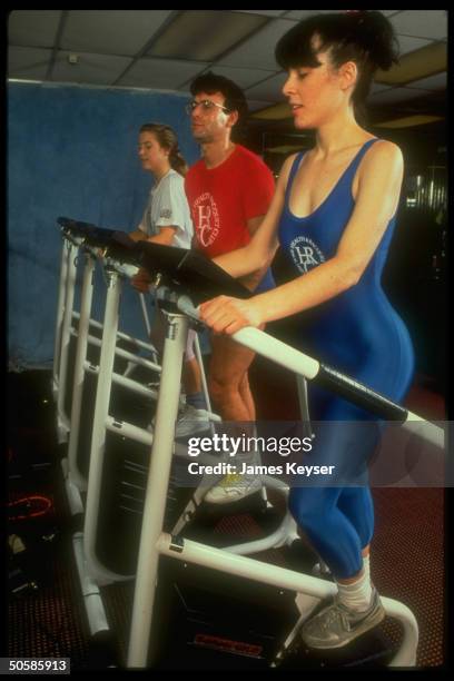 Members of NY Health & Raquet Club working out on StairMaster exercise machines.