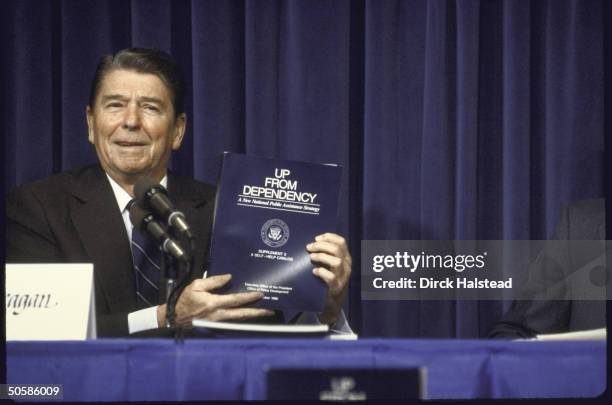 Pres. Ronald W. Reagan holding Up From Dependency exec. Branch self-help catalog, participating in welfare reform panel discussion.