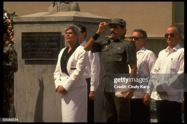 President Violeta Barrios de Chamorro standing with saluting Defense Minister General Humberto Ortega as he leads Army in pledging allegiance to her...