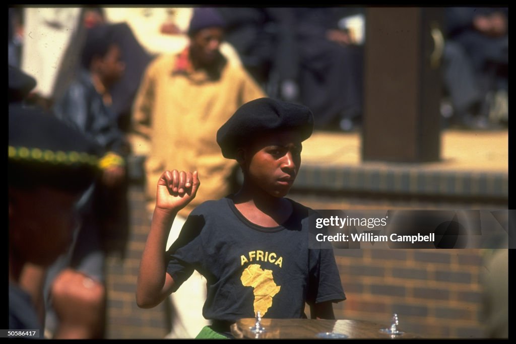Girl clenching fist at funeral for 12 vi
