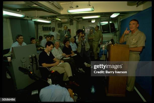 News anchorman Dan Rather among press et al being briefed on bd. USS Independence, covering gulf crisis spawned by Iraqi invasion of Kuwait .