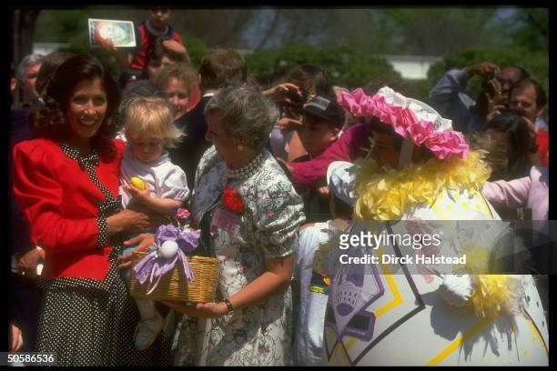Mrs VP Marilyn Quayle holding colored egg-gripping tot, mingling w. Children enjoying WH Easter egg hunt.