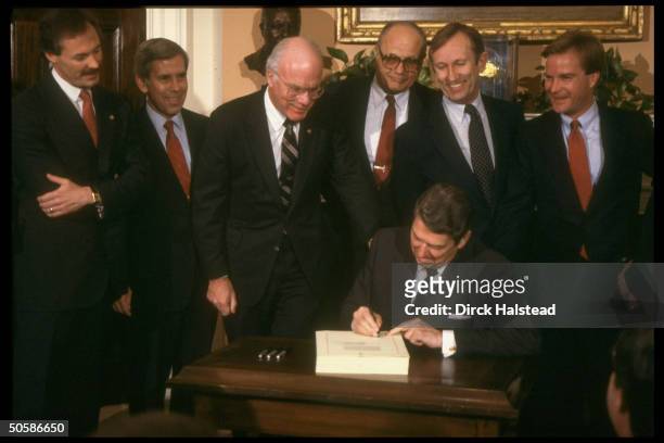 Pres. Reagan signing farm credit bill, w. Capitol Hillsters incl. Sens. Bumpers , Leahy , Lugar & Rep. Dingell looking on.