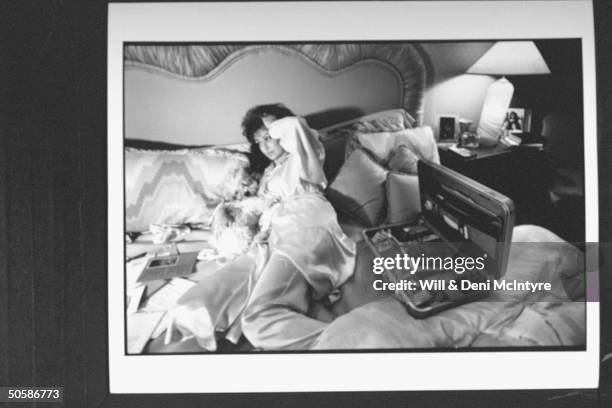 Naomi Judd, mother of mother-daughter C/W duo, lying in bed, going through correspondence while cuddling dog; suffering from chronic hepatitis. In...